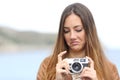 Upset woman looking her old slr photo camera Royalty Free Stock Photo