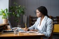 Upset woman looking at pc screen shocked with bad report sales result make notes for presentation Royalty Free Stock Photo