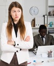 Upset woman and man colleague working with laptop on background in office Royalty Free Stock Photo