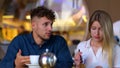 Upset woman and man talking in cafe about problem in relationships. Couple sitting at table in cafe together Royalty Free Stock Photo