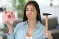 upset woman with piggy bank at home