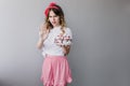 Upset woman in pink skirt posing with birthday cake. Studio photo of stylish girl with pie isolated Royalty Free Stock Photo