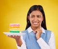 Upset woman, rainbow cake and studio while thinking of birthday celebration, disaster or mistake. Face of Indian gen z