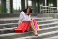 Upset woman sit on staircase, close face with hands, spent all money on clothes