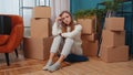 Upset woman sitting on floor near cardboard boxes with stuff, long relocation, bankruptcy, bank debt Royalty Free Stock Photo