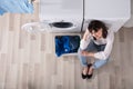 Upset Woman Sitting At Laundry Room