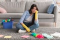 Upset woman tired of cleaning sitting on floor