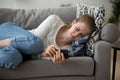 Upset worried young woman crying lying on couch holding phone Royalty Free Stock Photo