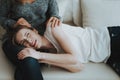 Upset Young Girl Lying on Mother`s Legs on Sofa. Royalty Free Stock Photo