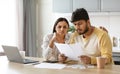 Upset young indian couple paying bills online Royalty Free Stock Photo