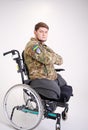 Upset young male looking at camera with sad look. He is sitting in invalid chairing wearing military uniform Handsome Royalty Free Stock Photo