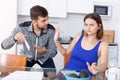 Upset young man with financial bills having conflict with woman