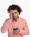 upset young man holding telephone and reading some bad news Royalty Free Stock Photo