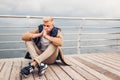 Upset young man sitting by sea on pier in Odessa thinking on rainy autumn day. Depression and stress concept Royalty Free Stock Photo