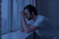 Upset young man staying awake all night, standing by wondow Royalty Free Stock Photo