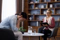 Upset young woman has counseling session with female psychologist in the office, telling her about problems Royalty Free Stock Photo