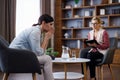 Upset young woman has counseling session with female psychologist in the office, telling her about problems Royalty Free Stock Photo