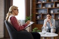 Upset young woman has counseling session with female psychologist in the office, telling her about problems Royalty Free Stock Photo