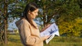 Upset woman in hoodie looks at missing cat posters in park