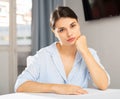 Upset young woman sitting at table