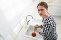 Upset woman using plunger to unclog sink drain in kitchen, above view Royalty Free Stock Photo