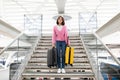 Upset young woman walking down stairs at airport with heavy suitcases Royalty Free Stock Photo