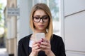 Upsetting message. Front view of a serious sad depressed girl checking a phone message walking on the street. Mixed race model in Royalty Free Stock Photo