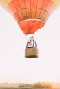 The upside close-up portrait of the newlyweds flying in the straw basket of the colourful airballoon.