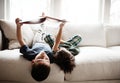 Upside down, comfortable and children reading books on sofa for knowledge, information and education. Relax, content and Royalty Free Stock Photo