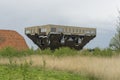 Upside down house under construction. Cloudy dark sky green grass holland farmland. Some trees and houseu nder construction