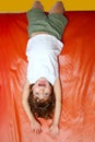 Upside down little girl on slide laughing Royalty Free Stock Photo