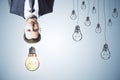 Upside down portrait of thoughtful man with drawn light bulbs on concrete wall background. Idea, inspiration and think outside the Royalty Free Stock Photo