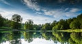 Upside Down Reflection of a Lush Green Forest and Blue Sky in a Calm Lake inverted water Royalty Free Stock Photo