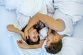 Upside down top view of an romantic, attractive, contented, hugging sexy loving couple in white bed, copy space Royalty Free Stock Photo