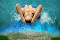 Upside view of a beautiful young sexy woman in Bikini under the splashing water of the waterfall in the Spa Wellness pool