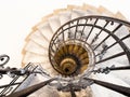 Upside view of indoor spiral winding staircase with black metal ornamental handrail Royalty Free Stock Photo