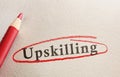 Upskilling text on paper circled in red pencil -- job training concept