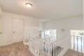 Upstairs landing white walls white railing and brown carpet