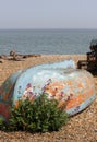 Upturned boat on a shingle beach Royalty Free Stock Photo