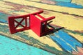 Upturned red chair on a colorful background