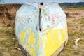 An upturned small boat washed up on the shoreline of a beautiful unspoiled beach