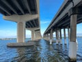 Looking up at bridgeÃ¢â¬â¢s infrastructure going over water with a bright blue sky background Royalty Free Stock Photo