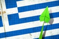 Upward arrow on the background of the flag of Greece. Paper plane. Economic recovery. Copy space. Business