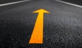 Bright Orange Arrow on Dark Asphalt Road Royalty Free Stock Photo
