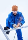 Upward shot of male technician cutting metal with cutting wheel in order to install photovoltaic solar panels Royalty Free Stock Photo