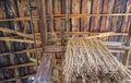 Upward view of the ceiling of an abandoned sheep shearing barn with hanging rope