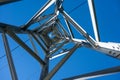 An upward view through a high voltage tower in a clear blue sky Royalty Free Stock Photo