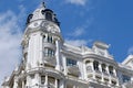 Upward view on rounded corner of classical white building in baroque architectural style with windows and balconies downtown of