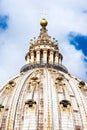 Upward view of St. Peter`s basilica dome with tourists sightseeing on the top.