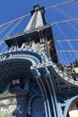 Upward view of a tower of the Manhattan Bridge with curved decorative steel work painted blue Royalty Free Stock Photo